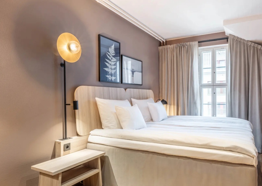 Guest room at Scandic Grand Marina with twin beds and warm wood furnishings